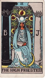 Die Tarotkarte Die Hohepriesterin aus dem Rider-Waite-Tarot: eine Frau mit Schriftrolle zwischen zwei Säulen